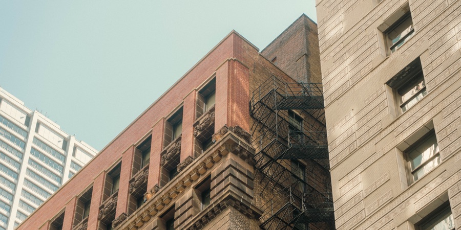 Brick facades and a fire escape beneath blue sky