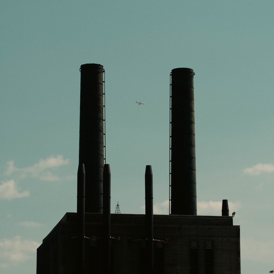 An airplane between two industrial chimneys