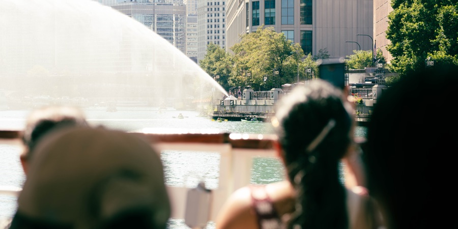 A sunlit river fountain seen from a boat